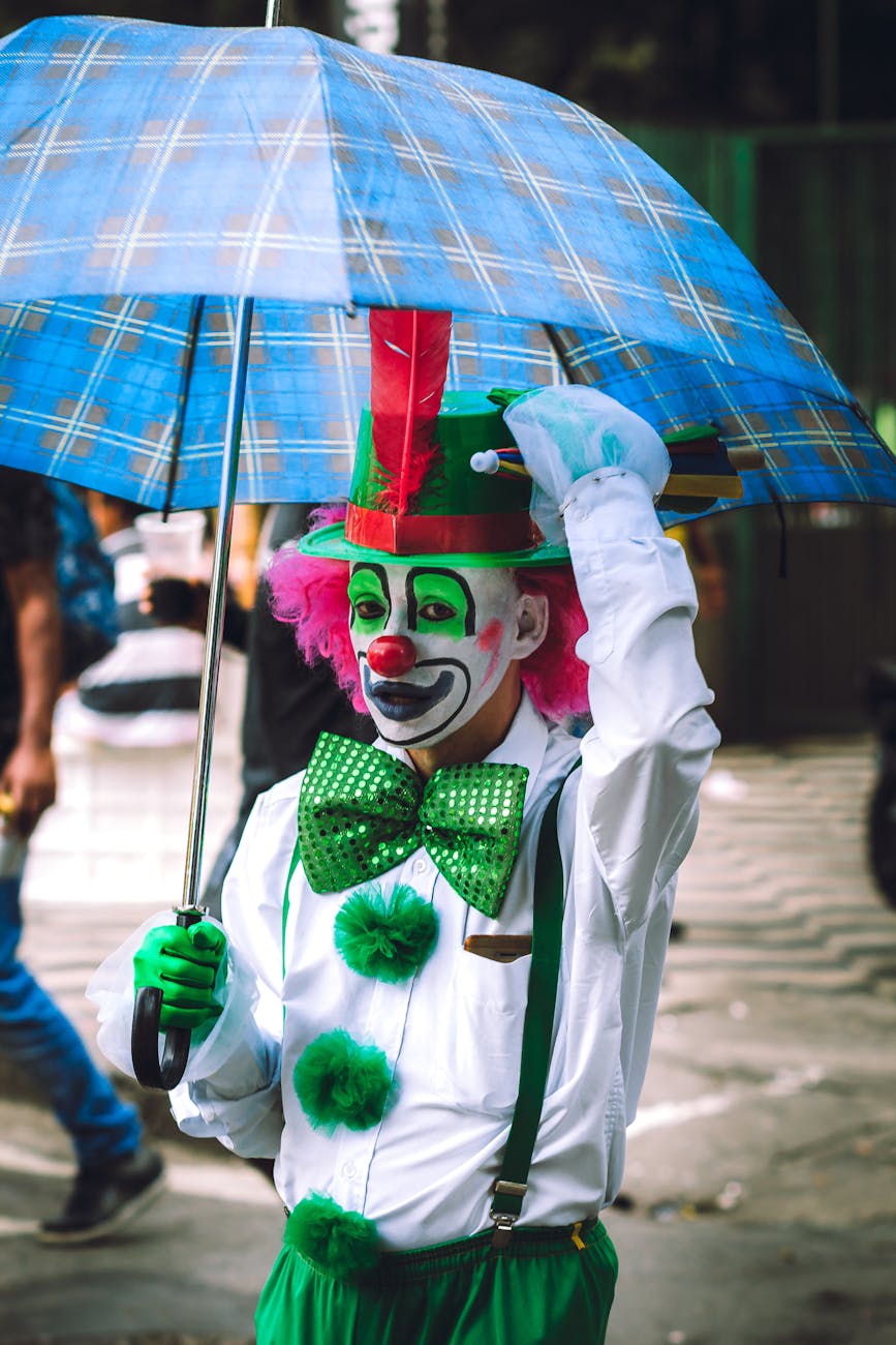 funny clown with makeup and costume on street with umbrella